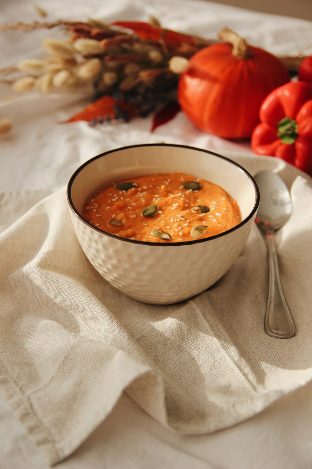 soup in white ceramic bowl beside stainless steel spoon