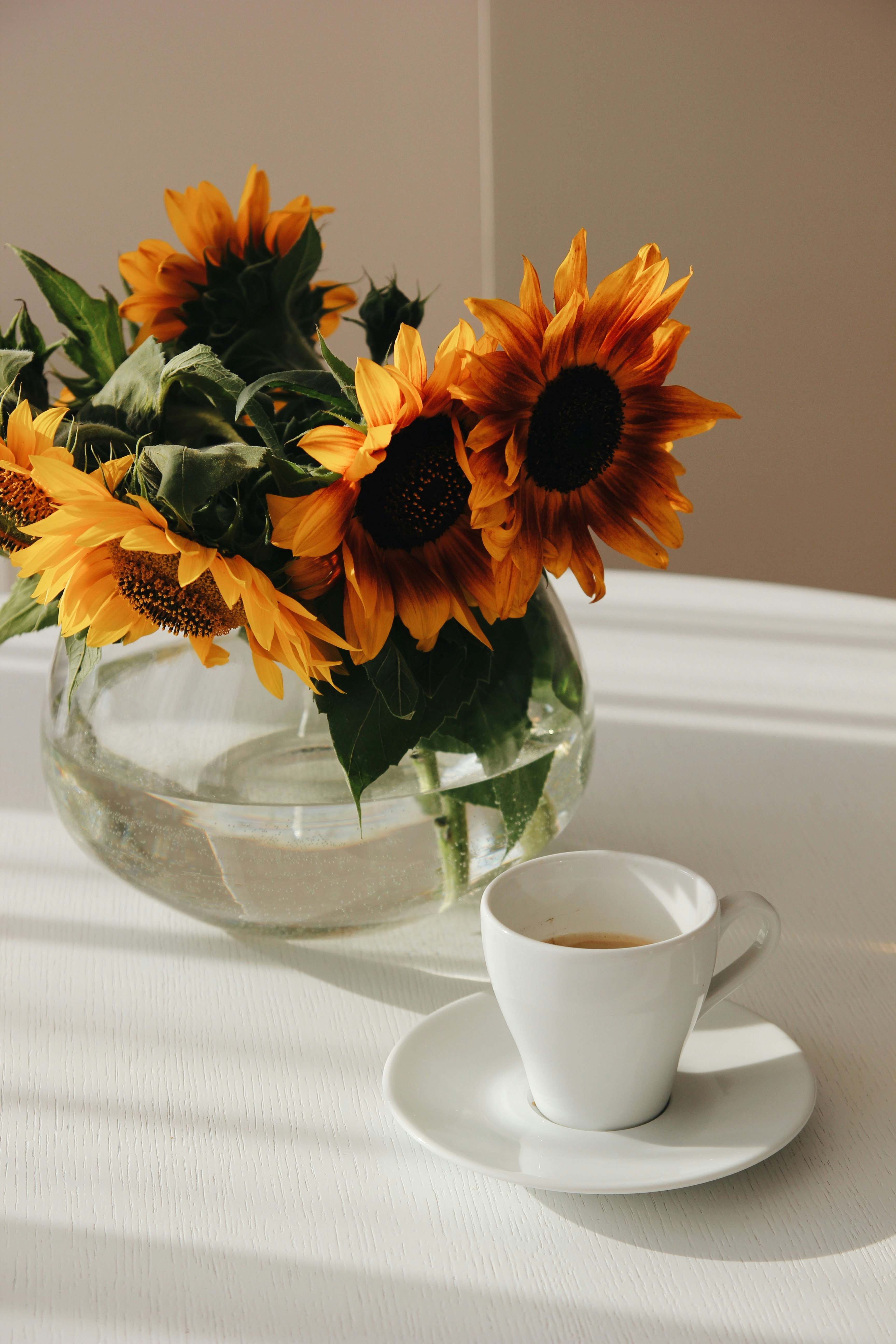 yellow and orange flowers in clear glass vase