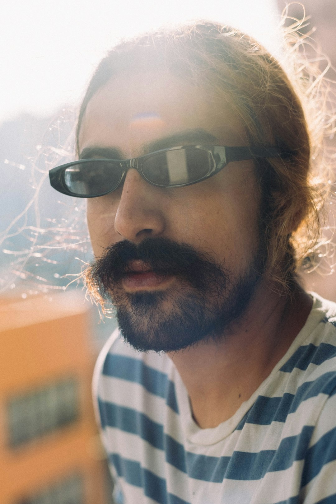 man in black sunglasses and white and black stripe shirt