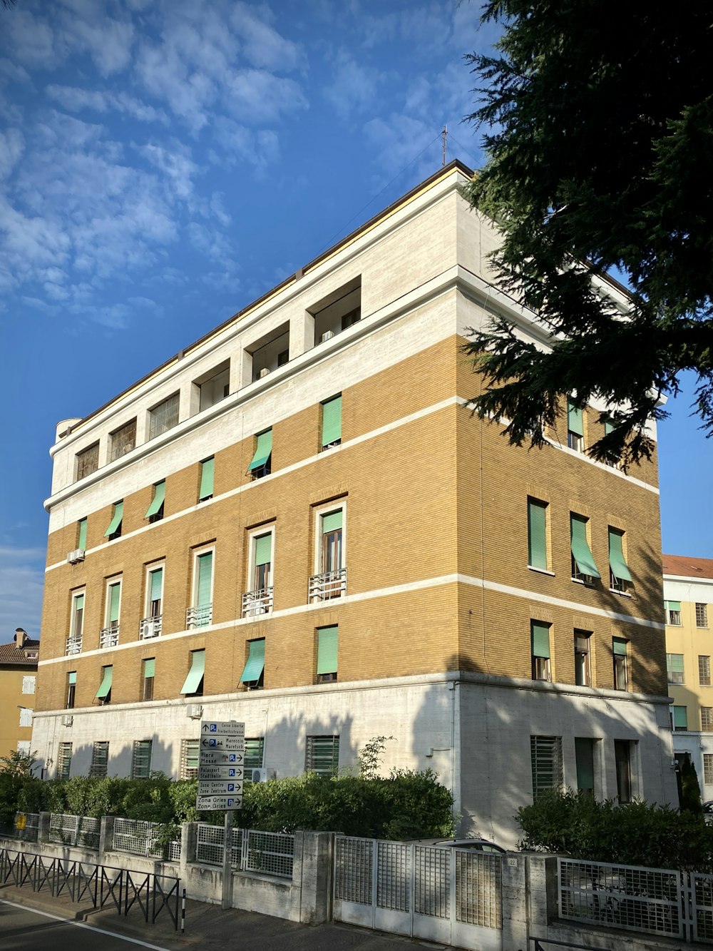 Edificio de hormigón marrón cerca de árboles verdes durante el día