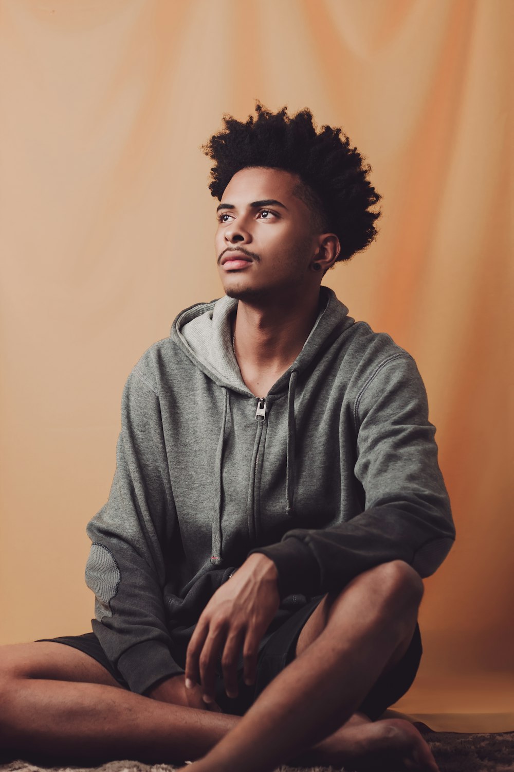 man in gray hoodie sitting on chair