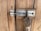 Close-up image of a vintage-style brass lock on a wooden door.