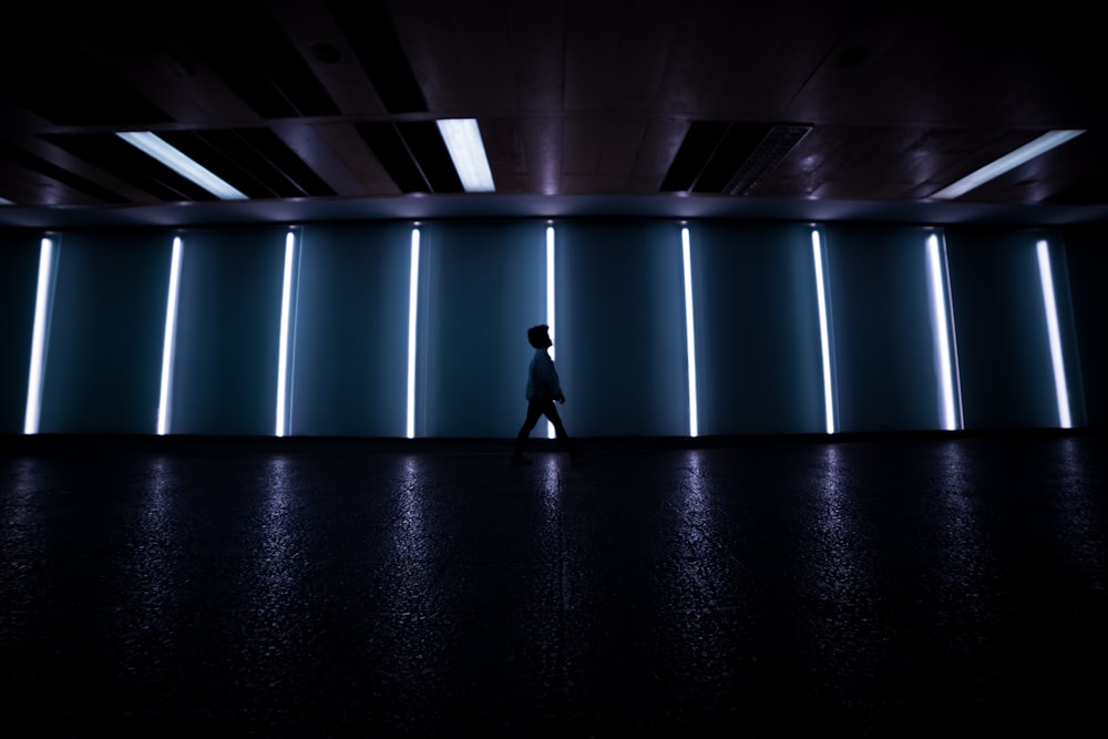 man in black suit walking on hallway