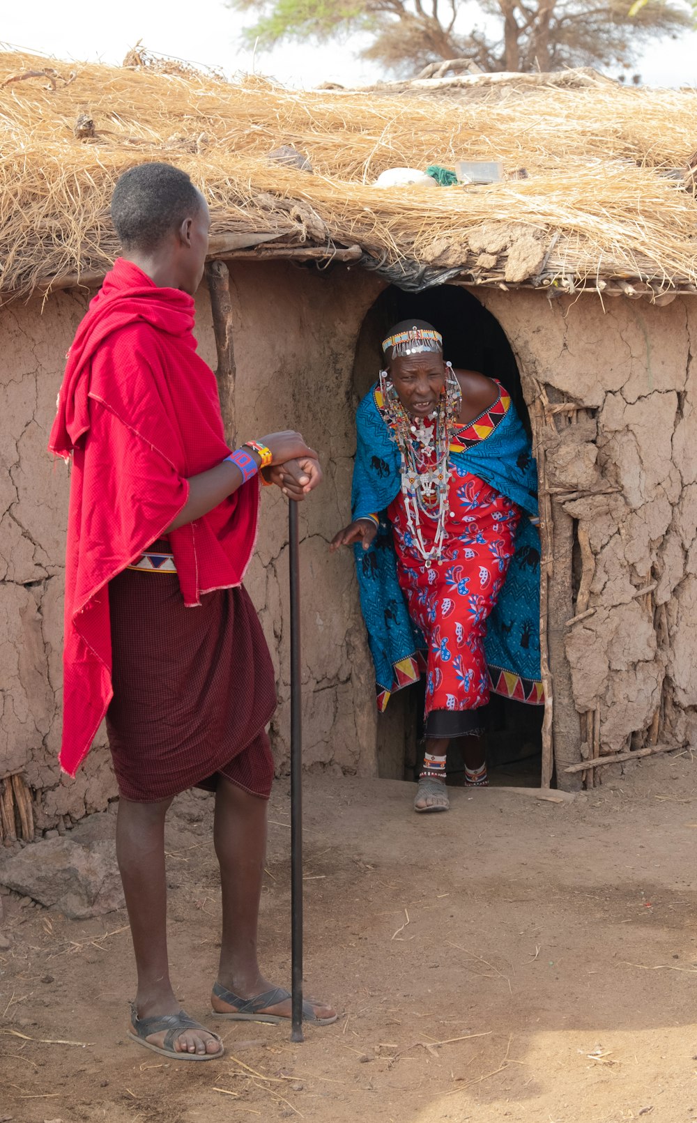 woman in red robe standing beside woman in blue and pink dress