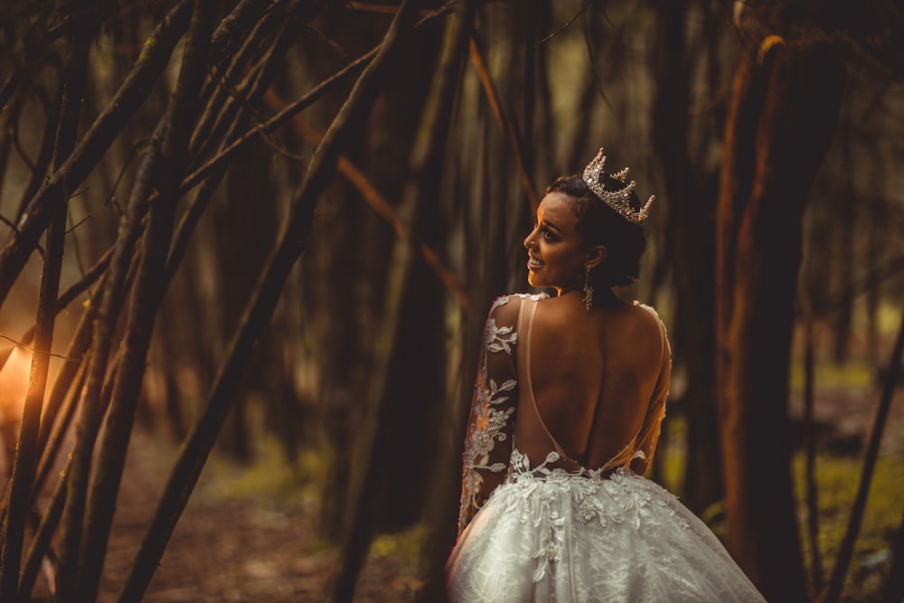 woman in white floral dress standing in woods