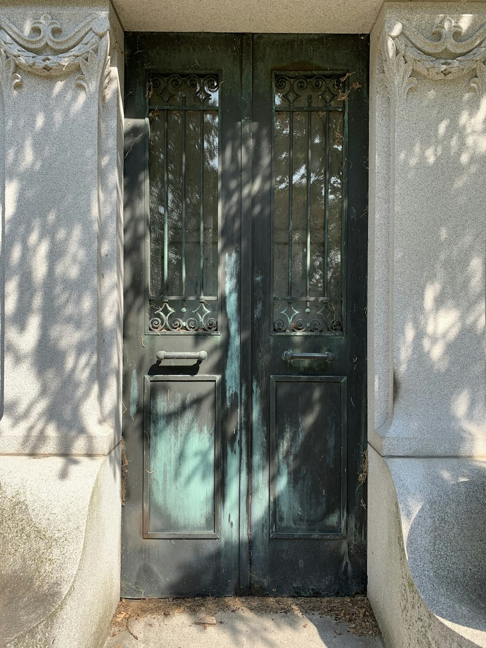 puerta de madera verde sobre pared de hormigón blanco