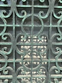 A charming wooden gate with intricate ironwork, newly repaired and polished.