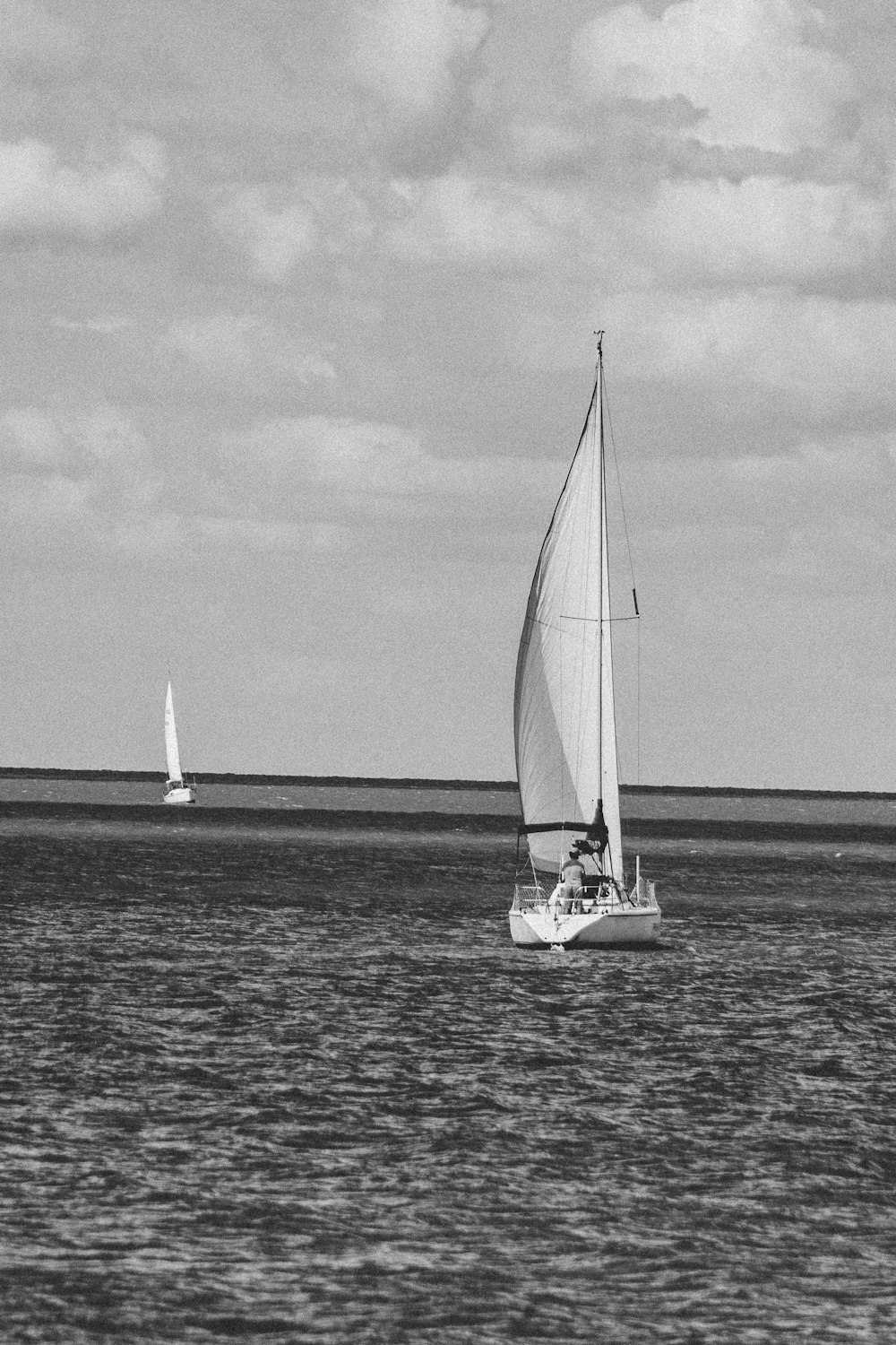 sailboat on sea in grayscale photography