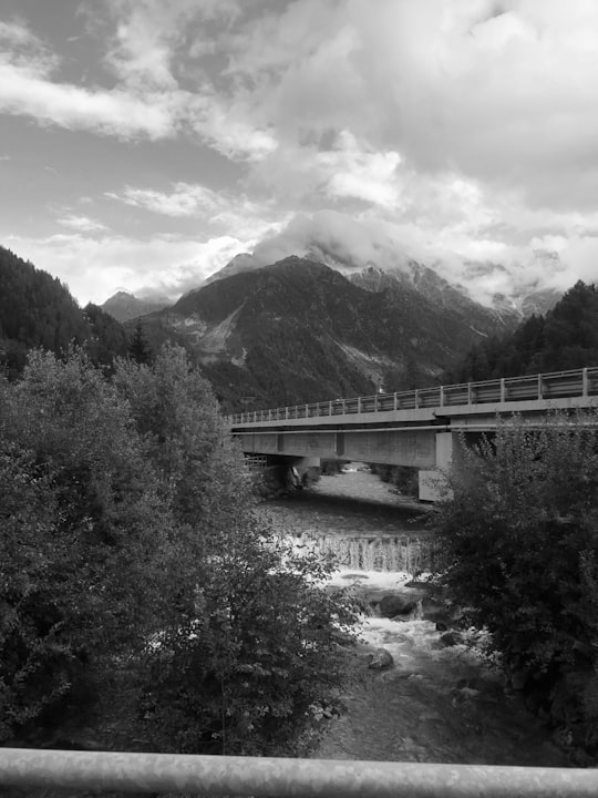 grayscale photo of bridge over river in Ponte di Legno Italy