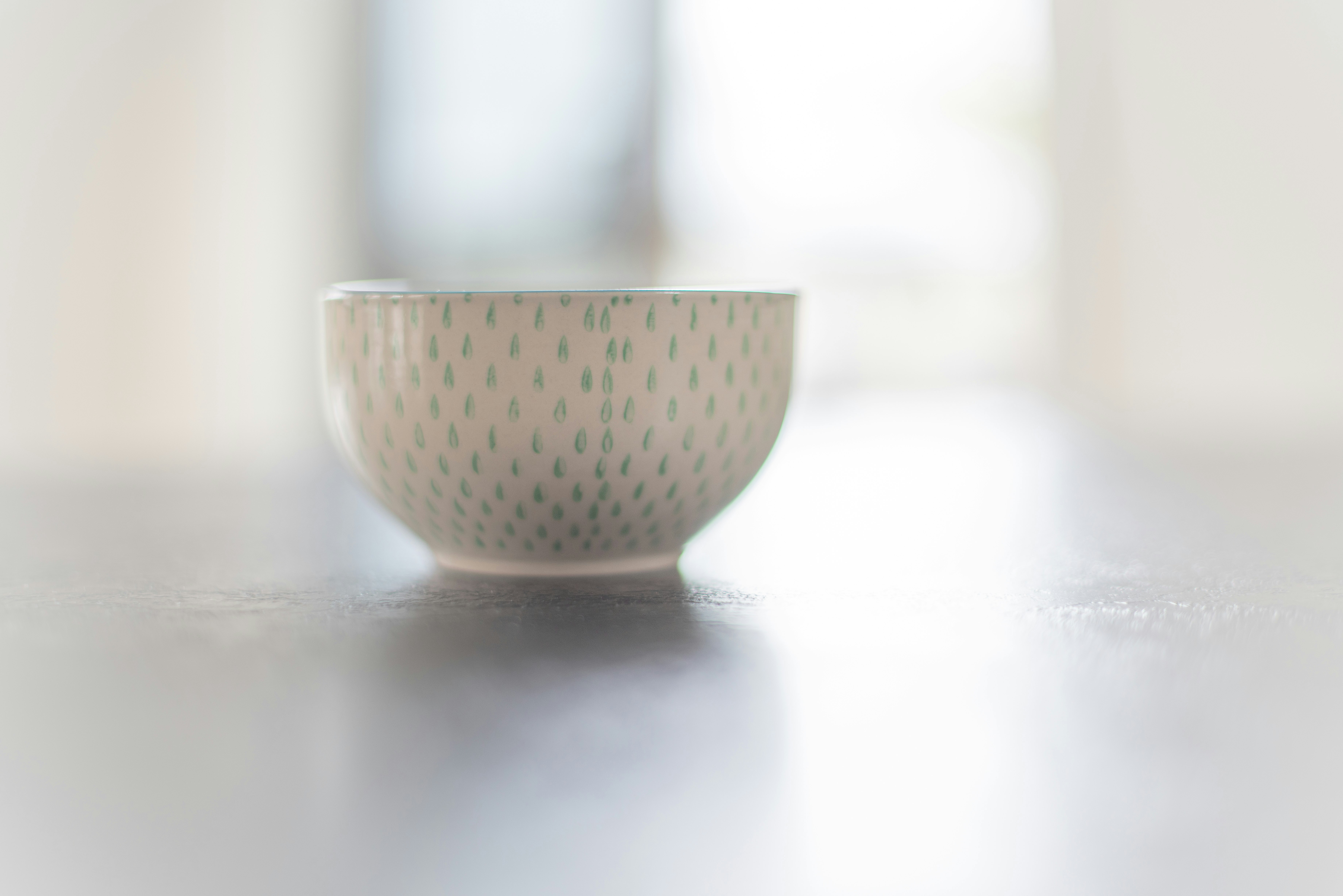 Cute Bowl With Green Dot Design Sitting On Counter With Lots Of Bokeh