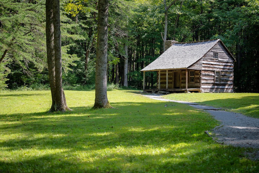 Casa de madera marrón en medio de un campo de hierba verde