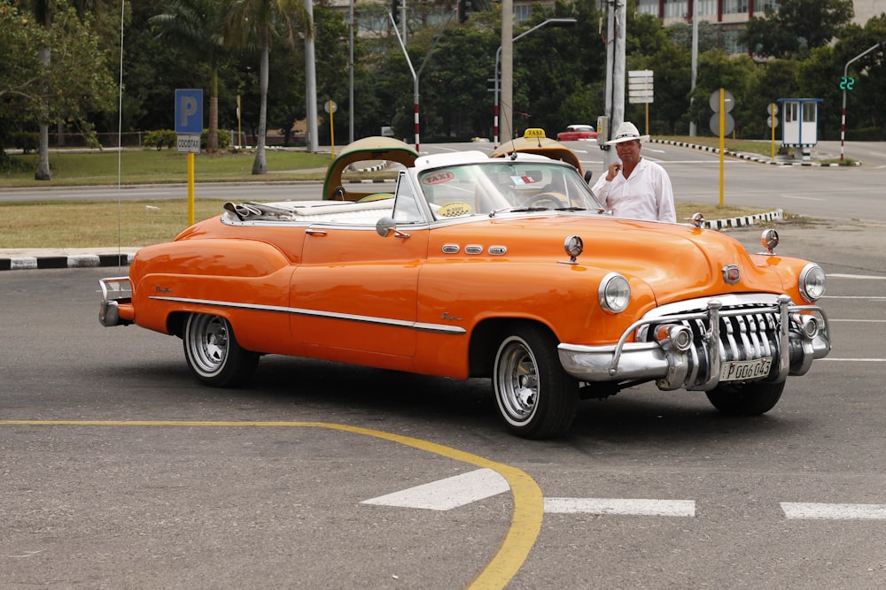 orange and white vintage car on road during daytime