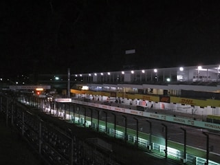 Quiet greyhound racing track with empty stands and calm surroundings.