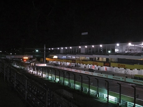 Quiet greyhound racing track with empty stands and calm surroundings.