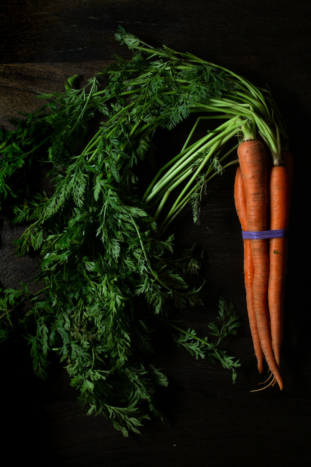 4 carrots on black wooden table