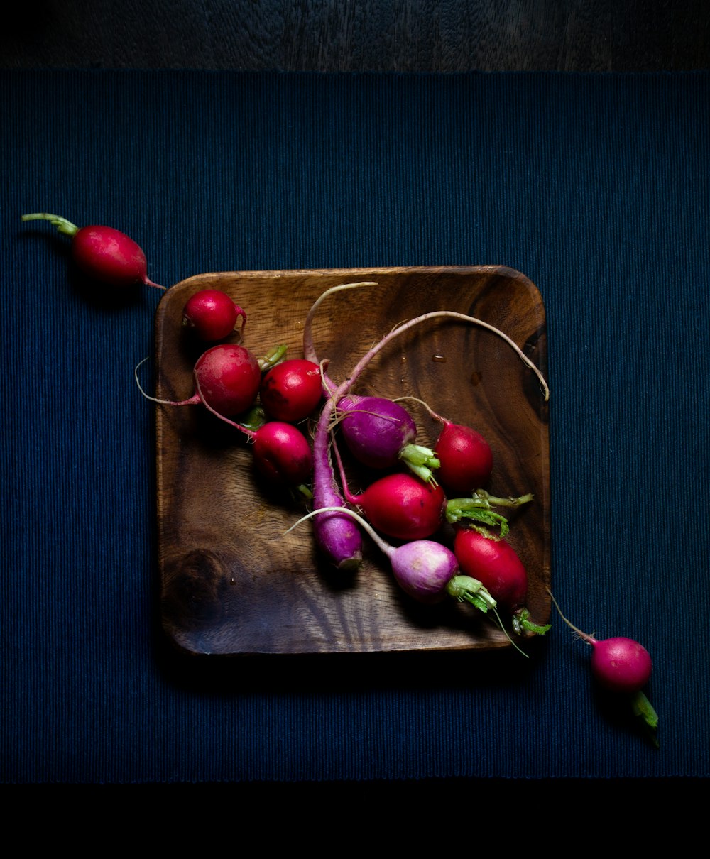 cerises rouges sur plateau en bois brun