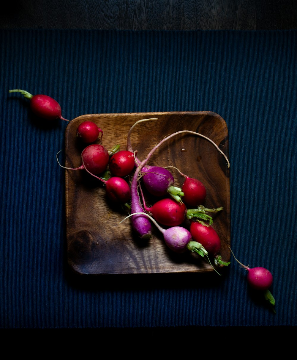 red cherries on brown wooden tray