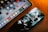A smartphone and a tablet are placed on a surface with a warm lighting ambiance. The smartphone screen displays an artistic, abstract wallpaper, while the tablet shows a variety of colorful application icons, including Google, Netflix, and others.