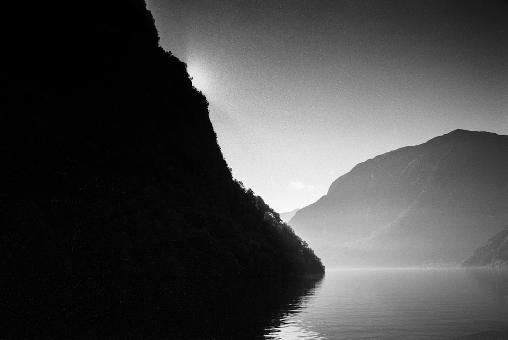 Foto en escala de grises del lago entre las montañas