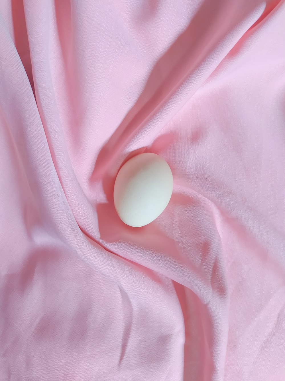 white egg on pink textile