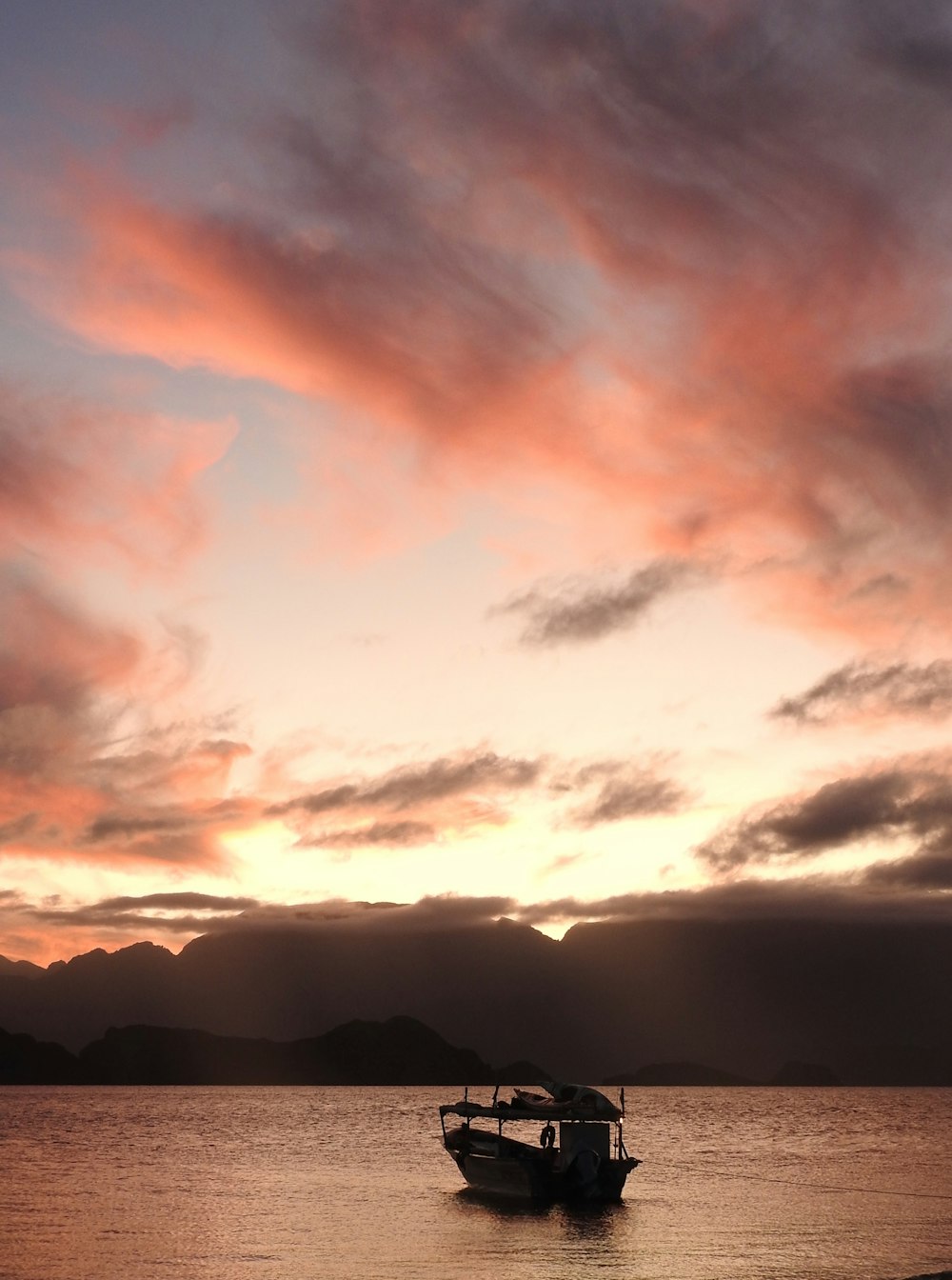 silhouette of mountain under cloudy sky during sunset