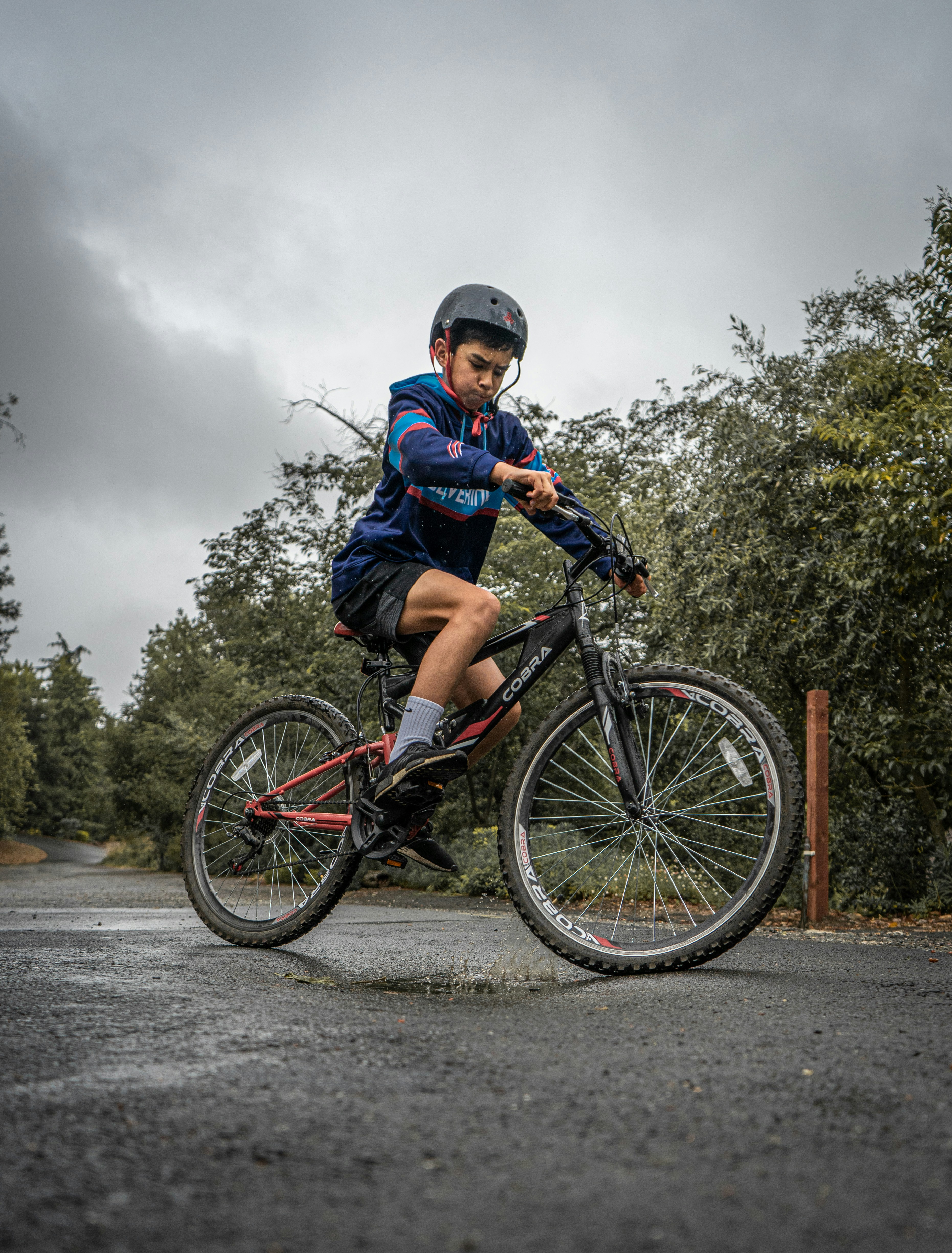 boy in blue and red jacket riding on bicycle