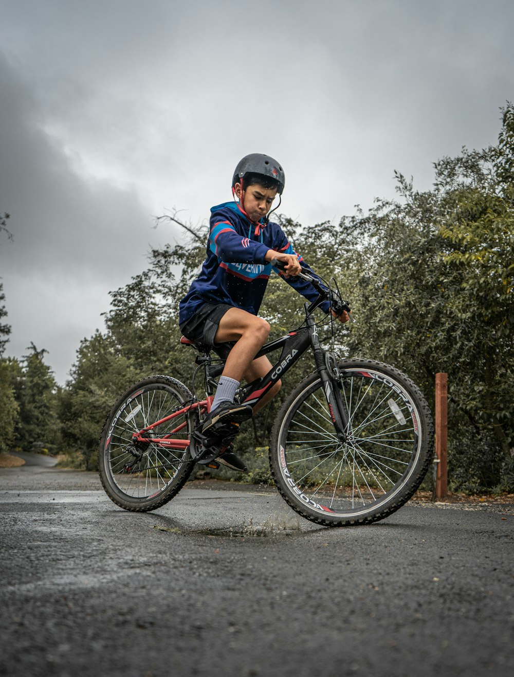 boy in blue and red jacket riding on bicycle