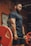 Photo of a muscular man lifting weights in a gym with bold black and red colors.