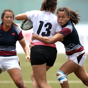 women in black and white jersey shirt playing soccer