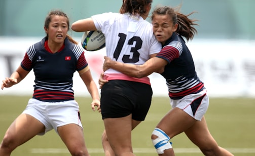 women in black and white jersey shirt playing soccer