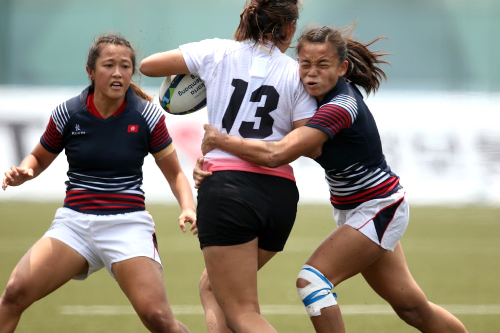 women in black and white jersey shirt playing soccer