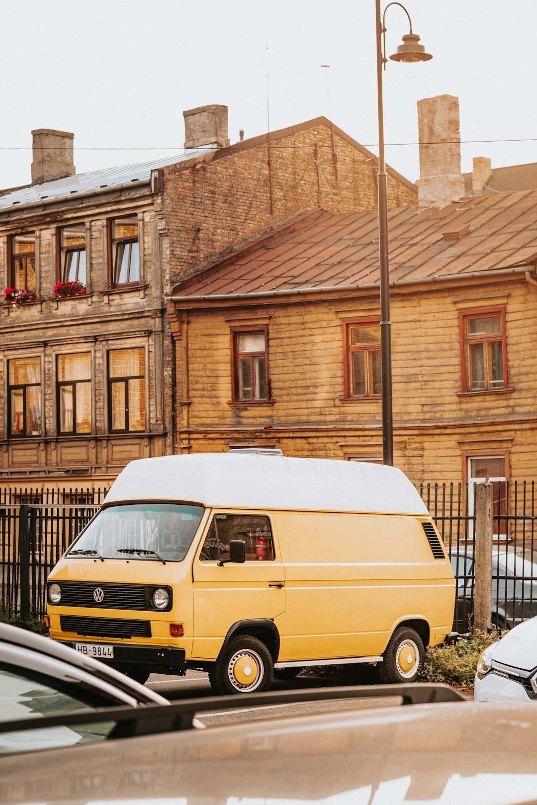 yellow van parked beside brown building during daytime