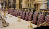 A grand dining table with detailed hand carvings, set in a space inspired by Arabian royal aesthetics.