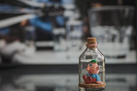 clear glass bottle with brown and red lid