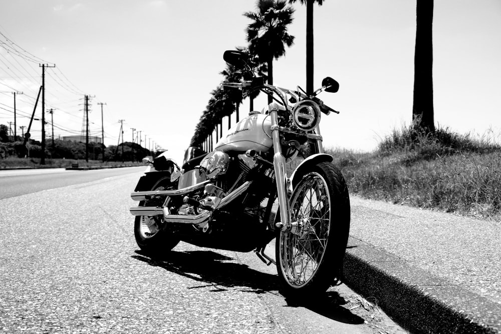 Foto en escala de grises de una motocicleta estacionada en la carretera