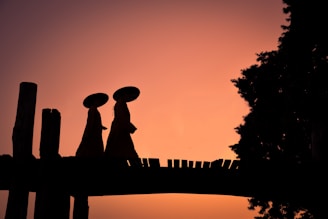silhouette of man and woman statue during sunset