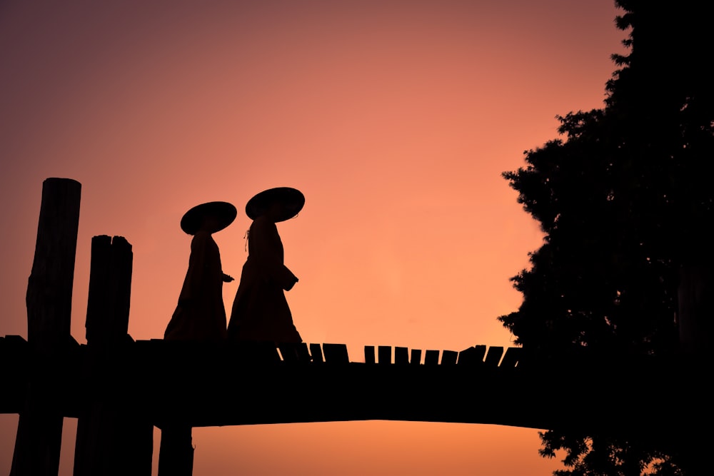 Silhouette der Statue von Mann und Frau bei Sonnenuntergang