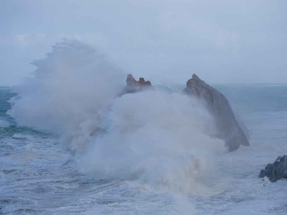 ocean waves hitting gray rock formation during daytime