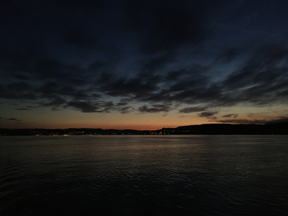 body of water under cloudy sky during daytime