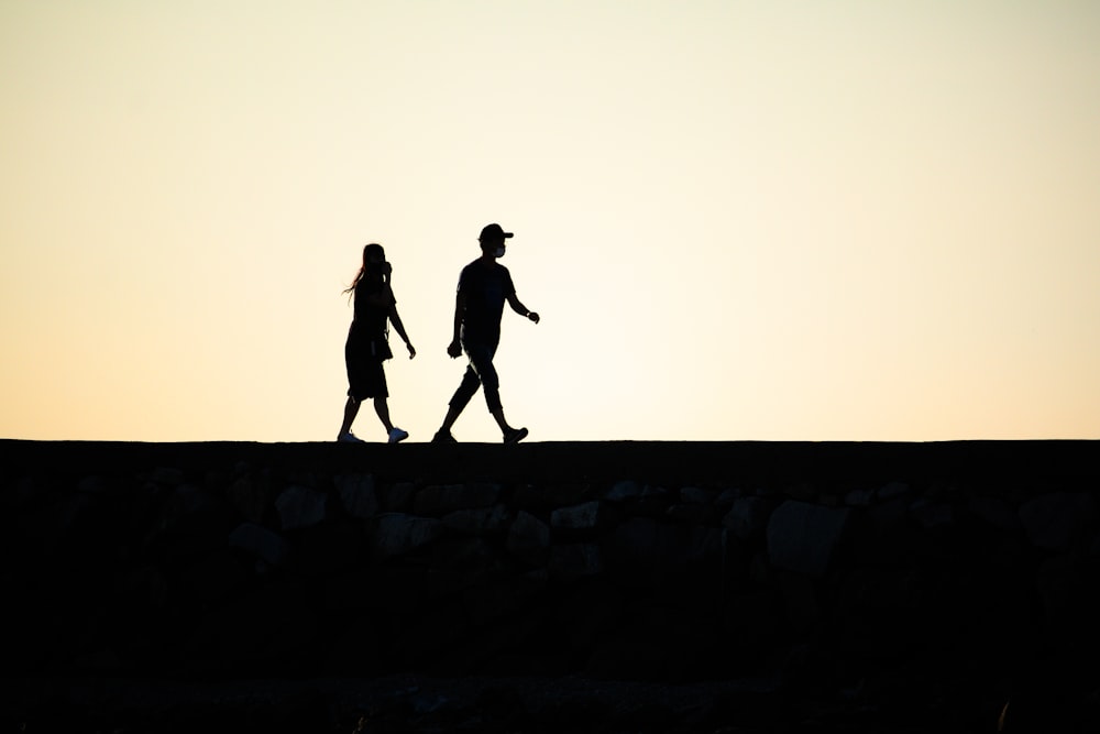 silhouette of 2 person walking on the street