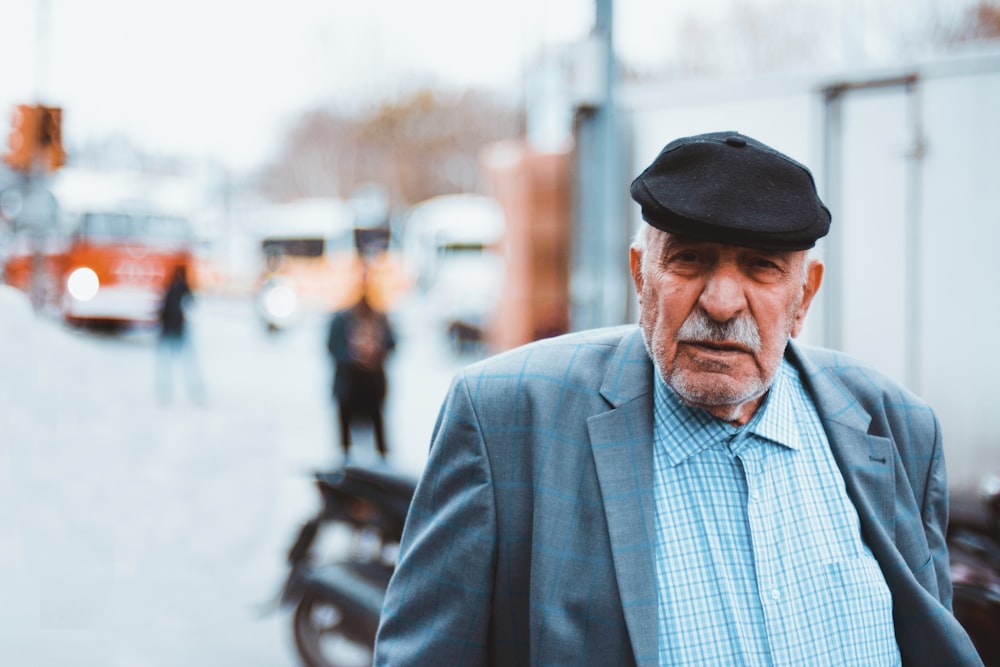 man in blue and white plaid dress shirt wearing black fedora hat