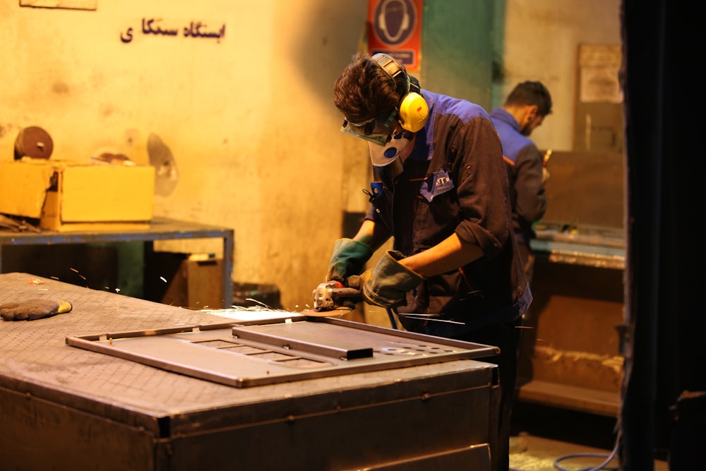 man in blue shirt and green pants wearing yellow helmet