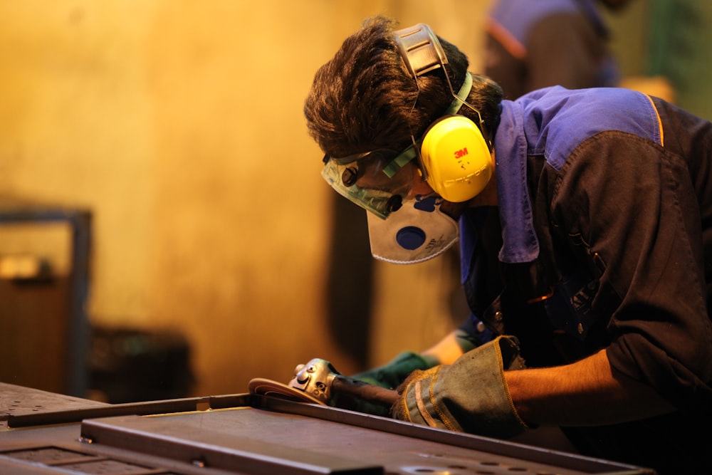 man in blue denim jacket wearing yellow helmet