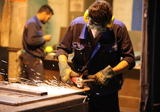 man in black long sleeve shirt holding gray metal tool