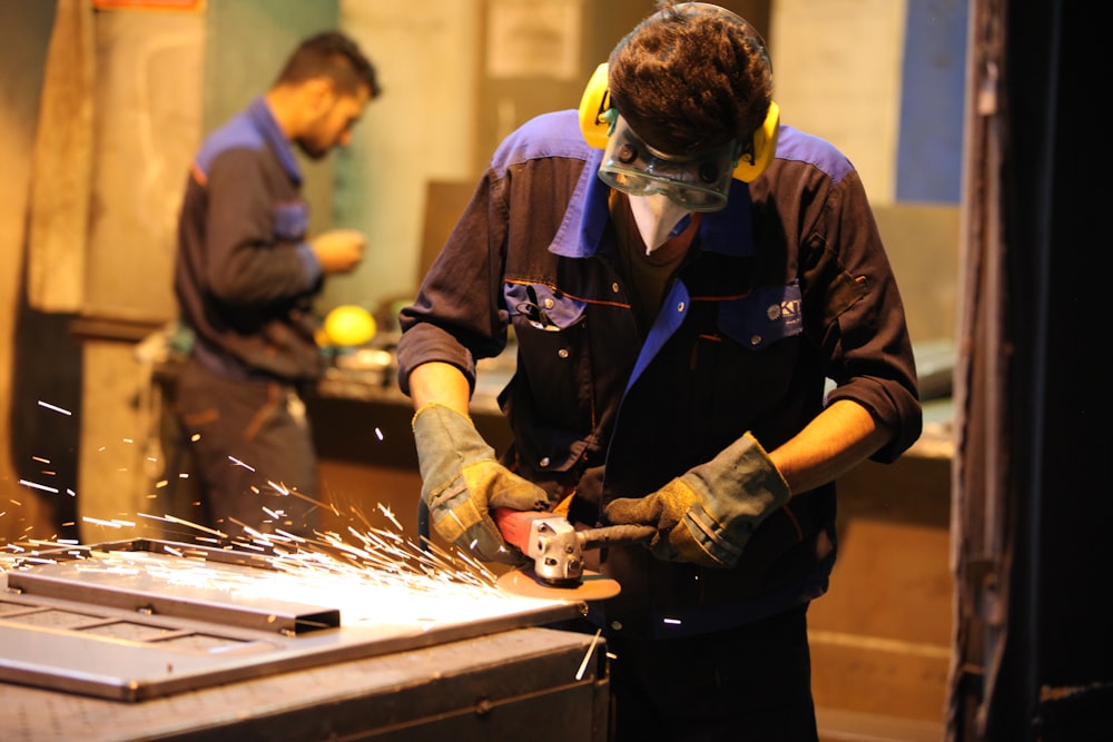 man in black long sleeve shirt holding gray metal tool