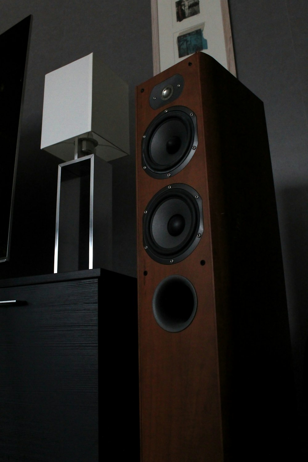 black and silver speaker on brown wooden cabinet
