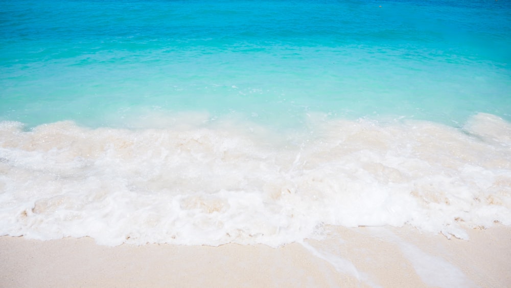 sea waves crashing on shore during daytime