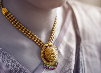 Close-up of a delicate handmade South Indian temple necklace resting on natural linen fabric, highlighting intricate craftsmanship.