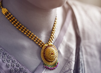 Close-up of an elegant gold necklace with intricate Indian craftsmanship on a velvet display