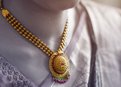 person wearing gold and silver necklace